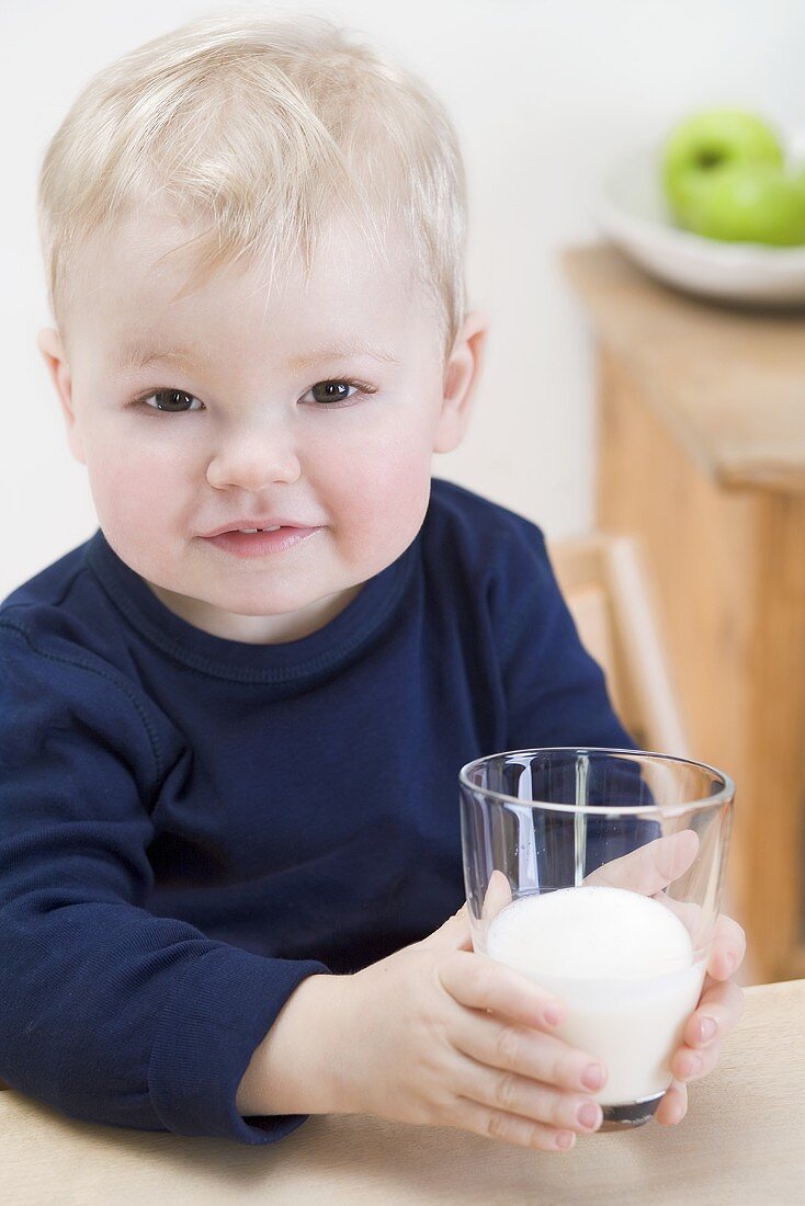 Kleiner Junge mit einem Glas Milch