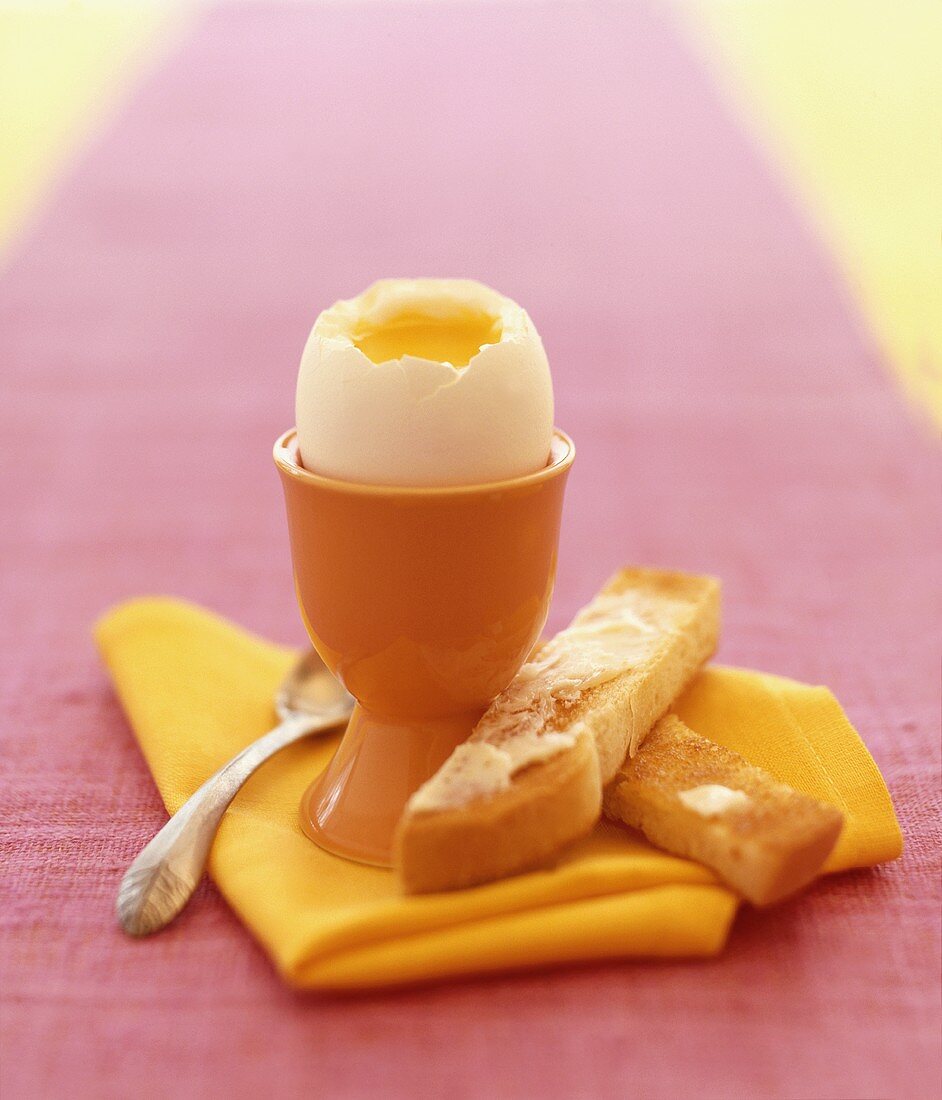 Weichgekochtes Ei im Eierbecher und Toaststreifen