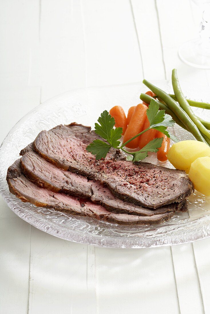 Three slices of roast beef with vegetables