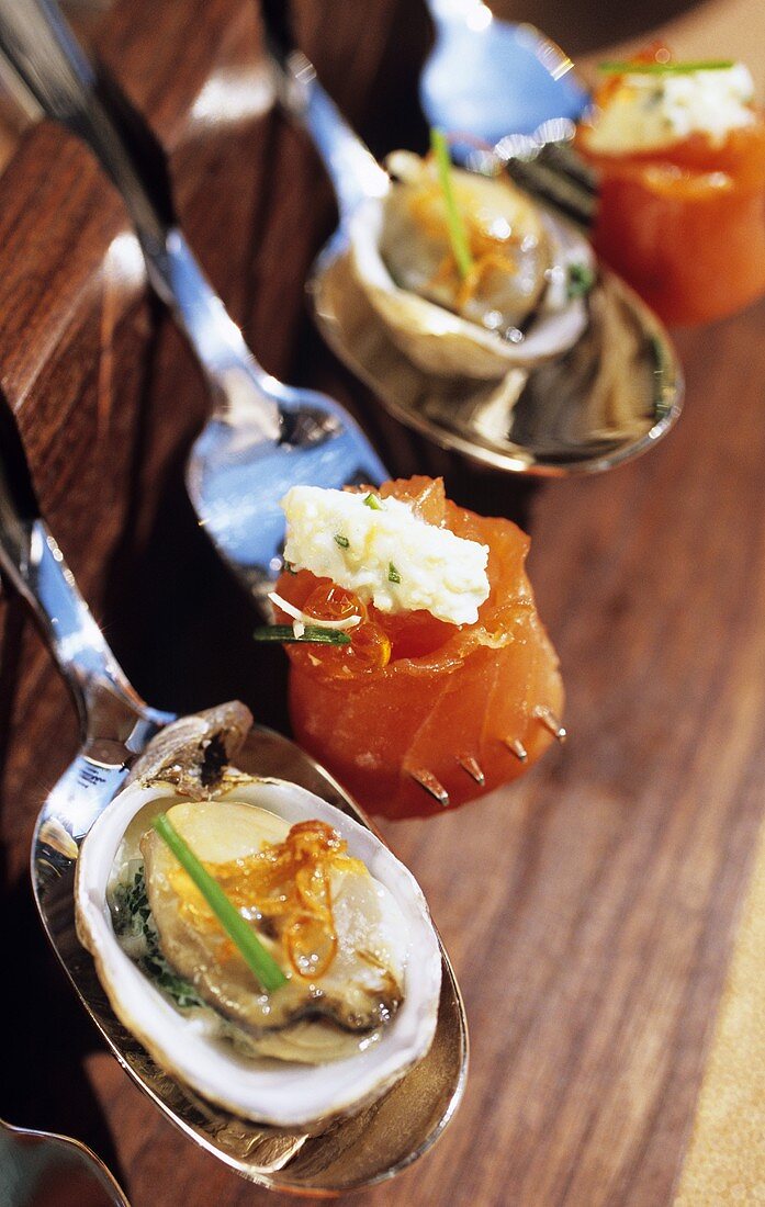 Oyster and salmon appetisers on spoons and forks