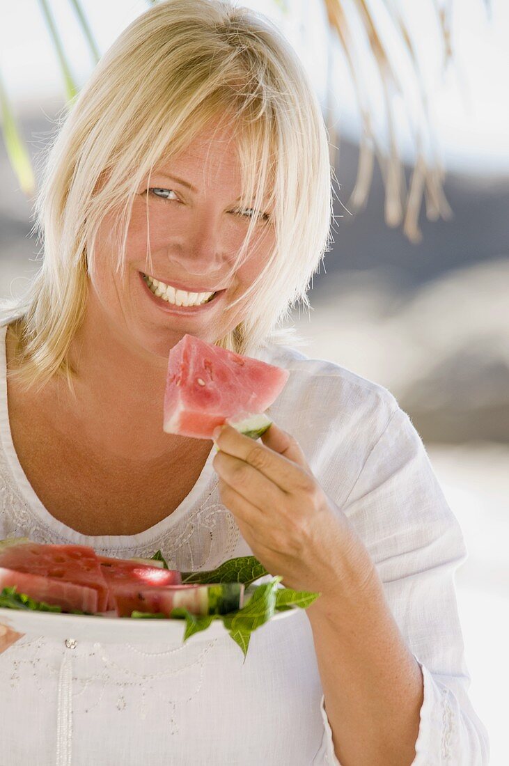 Blonde Frau isst Wassermelone