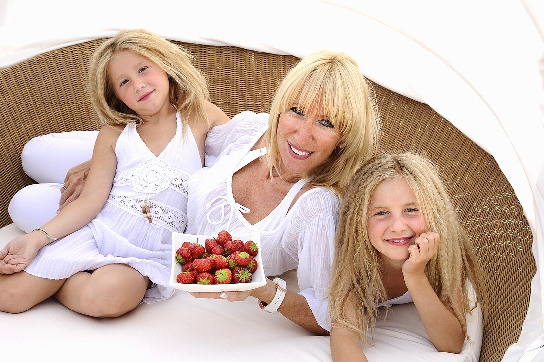 Mutter und Töchter mit Erdbeeren