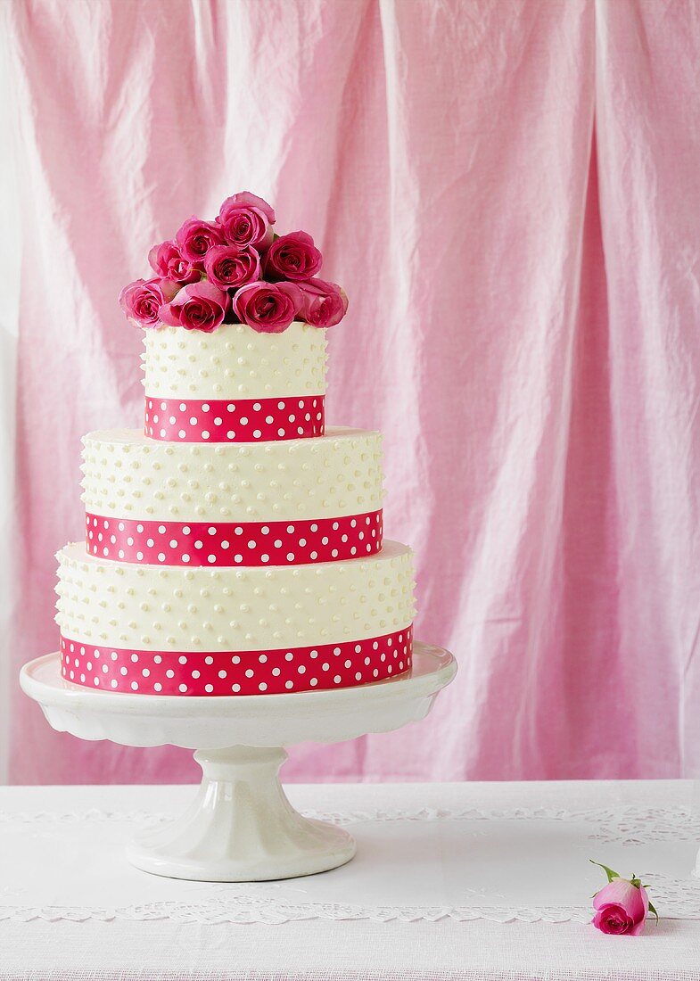 A wedding cake with red roses