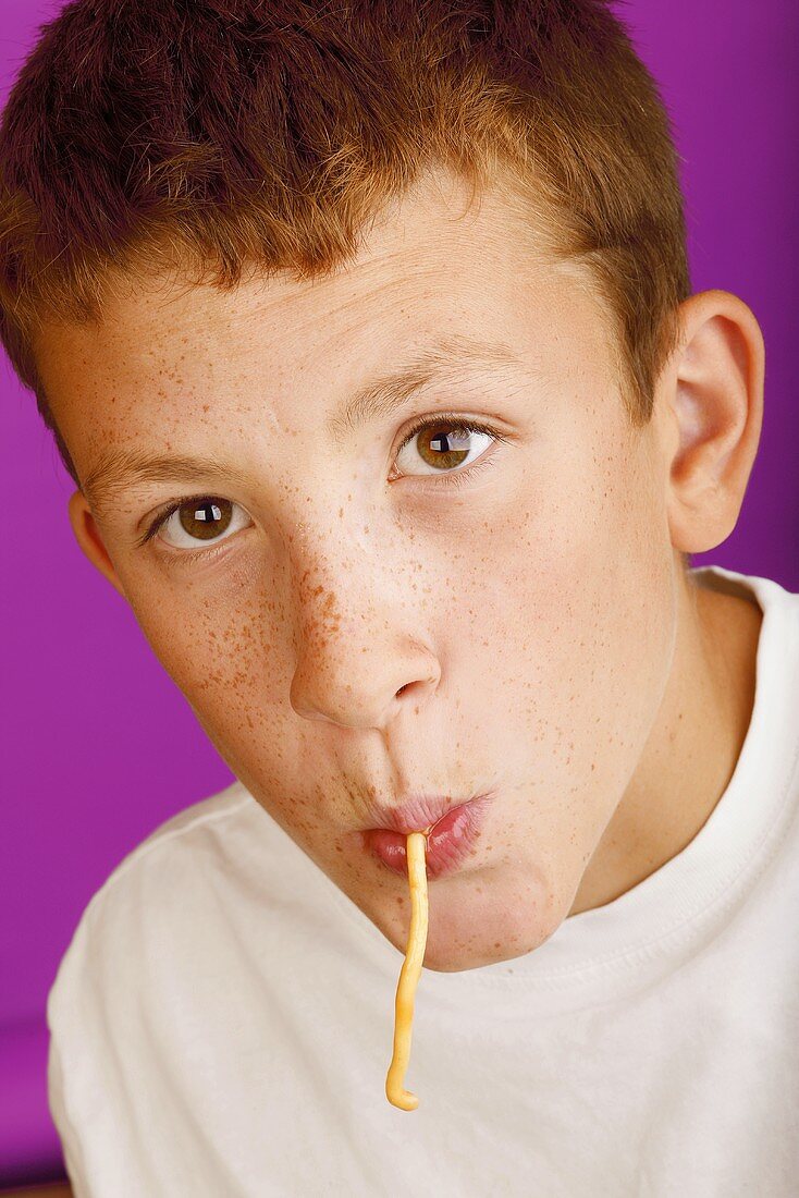 Junge mit Spaghetti im Mund