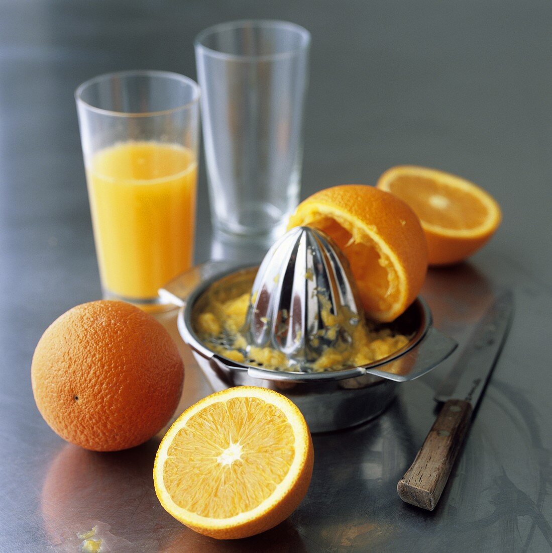 Oranges, citrus squeezer and freshly squeezed orange juice