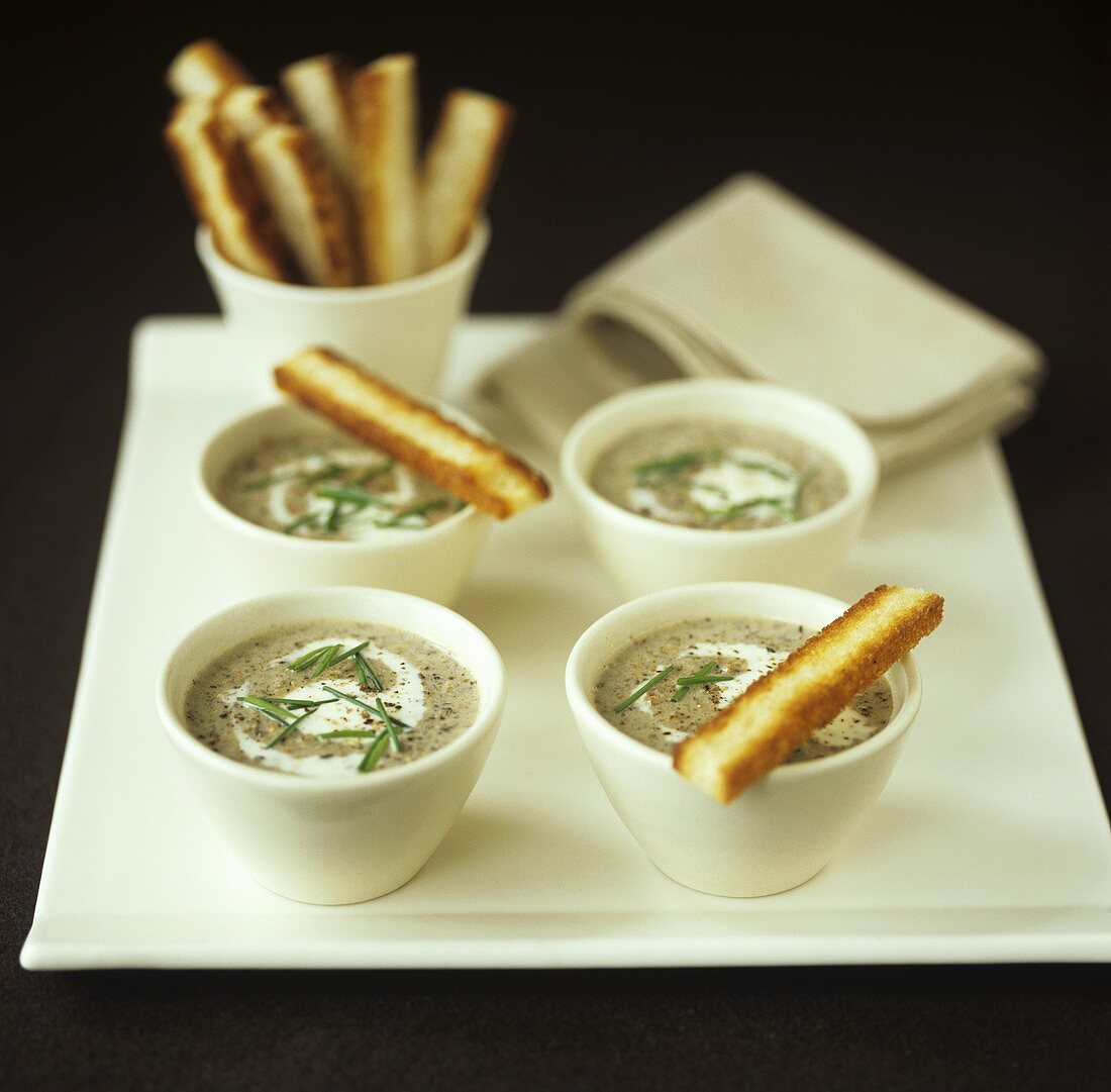 Mushroom soup with crème fraîche, chives and bread sticks