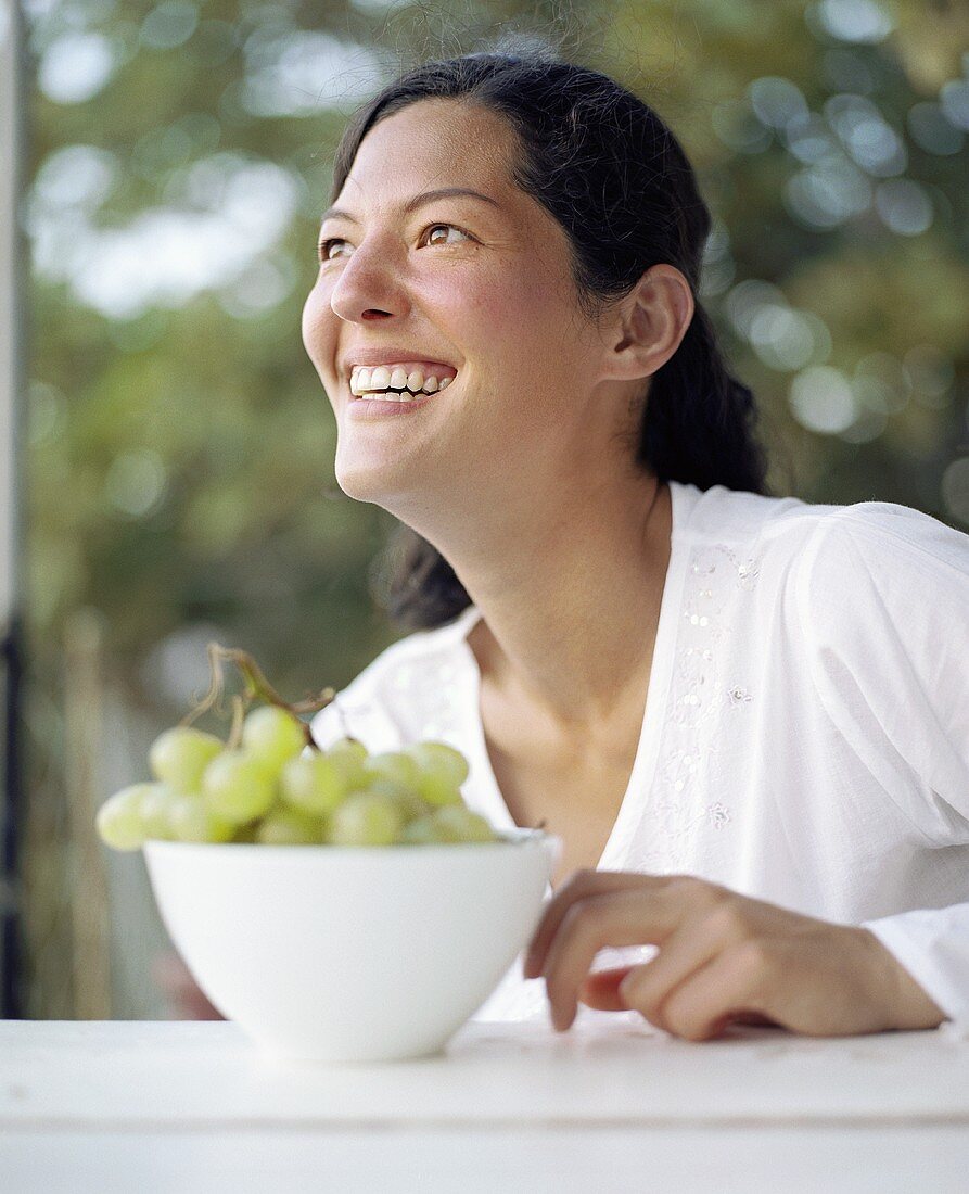 Young woman with a bowl of grapes