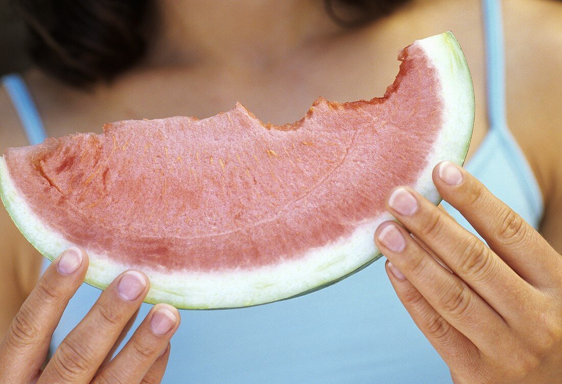 Hände halten ein Stück Wassermelone