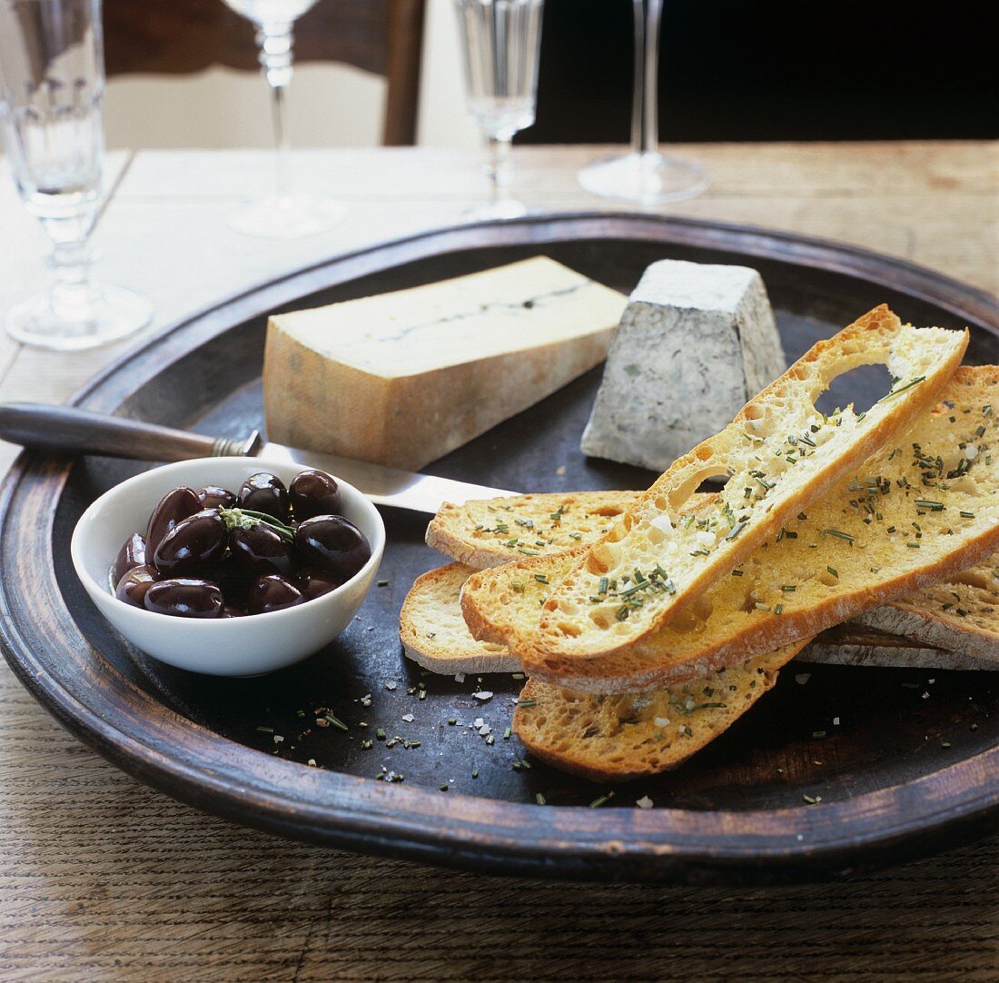 Kräuterbaguette mit schwarzen Oliven und Käse