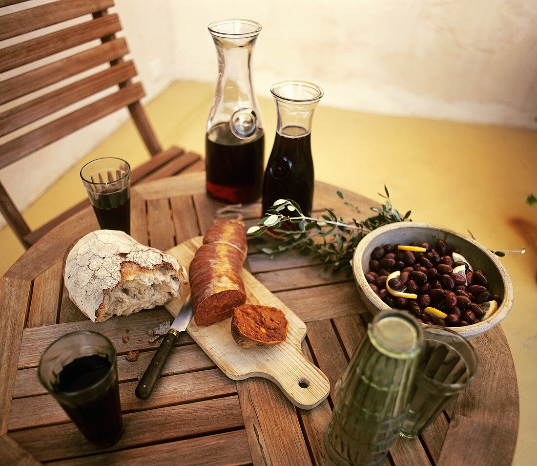 Paprika sausage, bread, olives and red wine