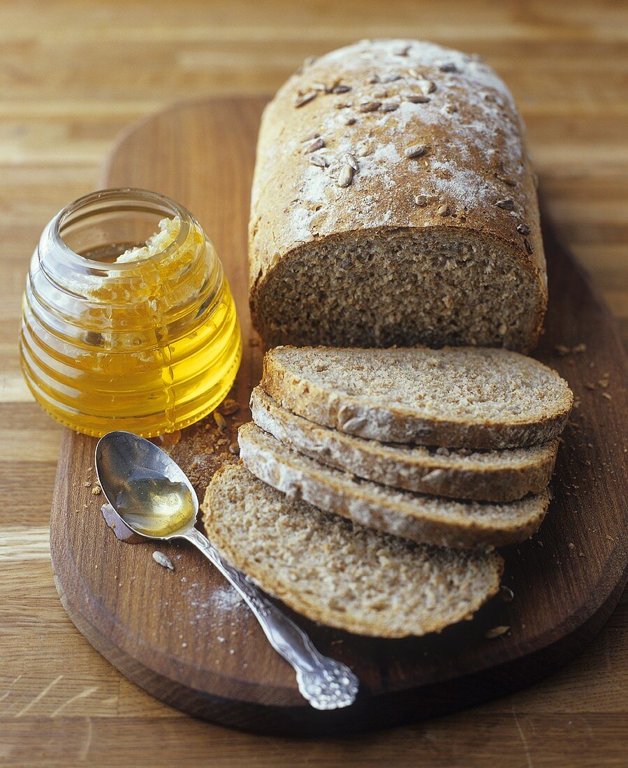 Jar of honey & loaf of wholemeal bread with sunflower seeds