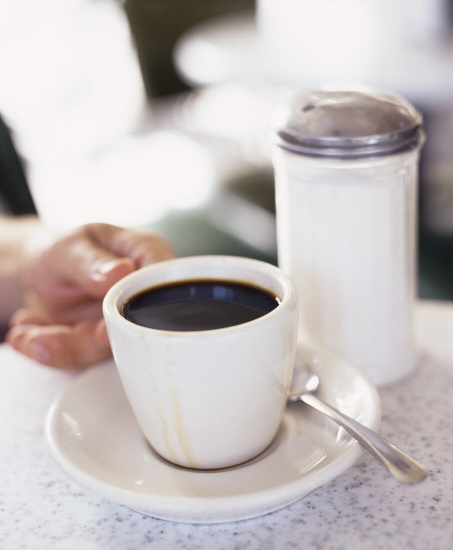 Cup of coffee, sugar shaker