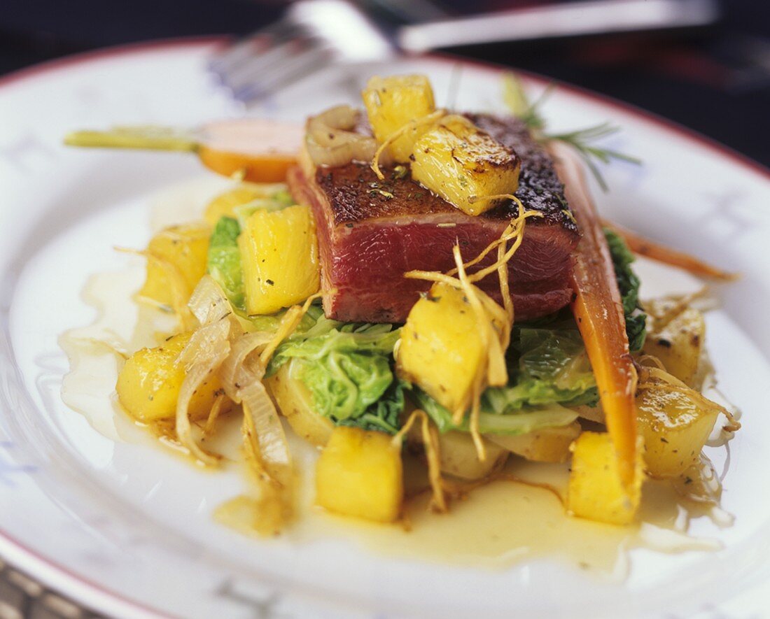 Roast duck breast with pineapple on vegetables