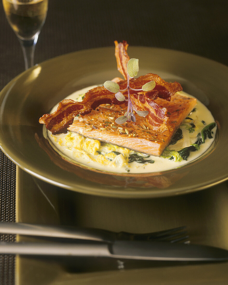 Salmon with fried bacon and herbs on creamed savoy cabbage