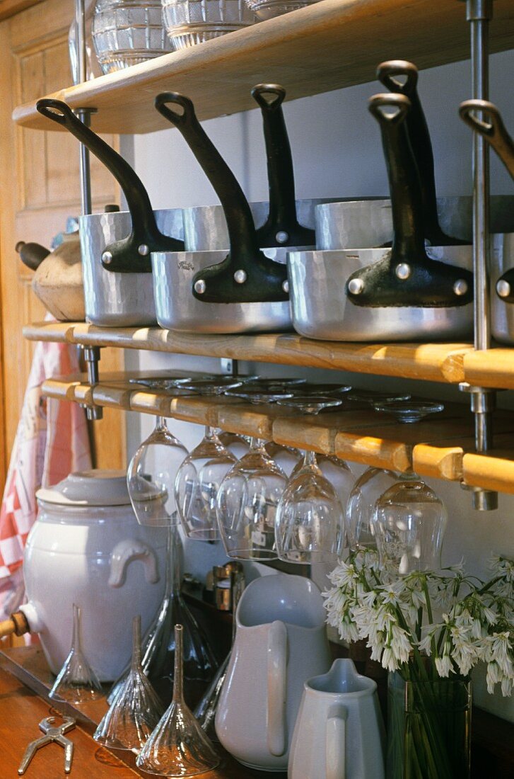Saucepans, glasses and crockery on kitchen shelves