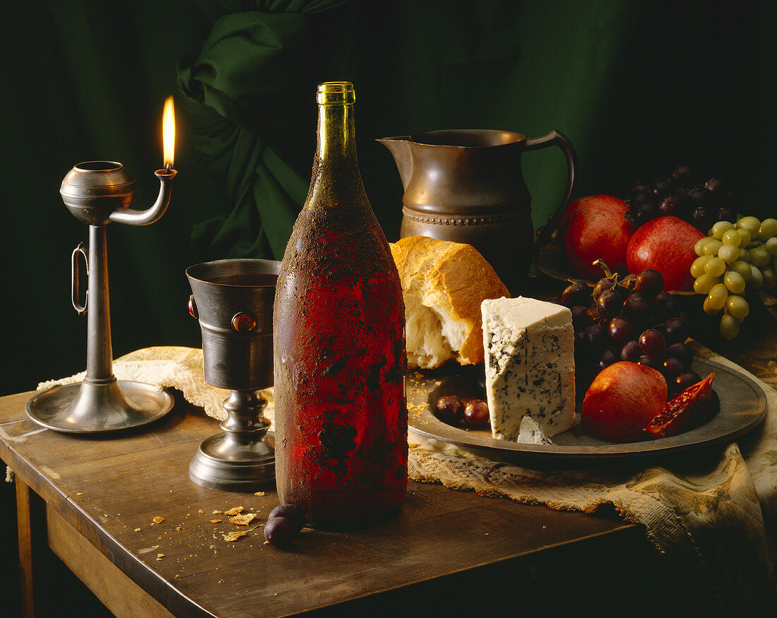 Still life with red wine, cheese, fruit and white bread