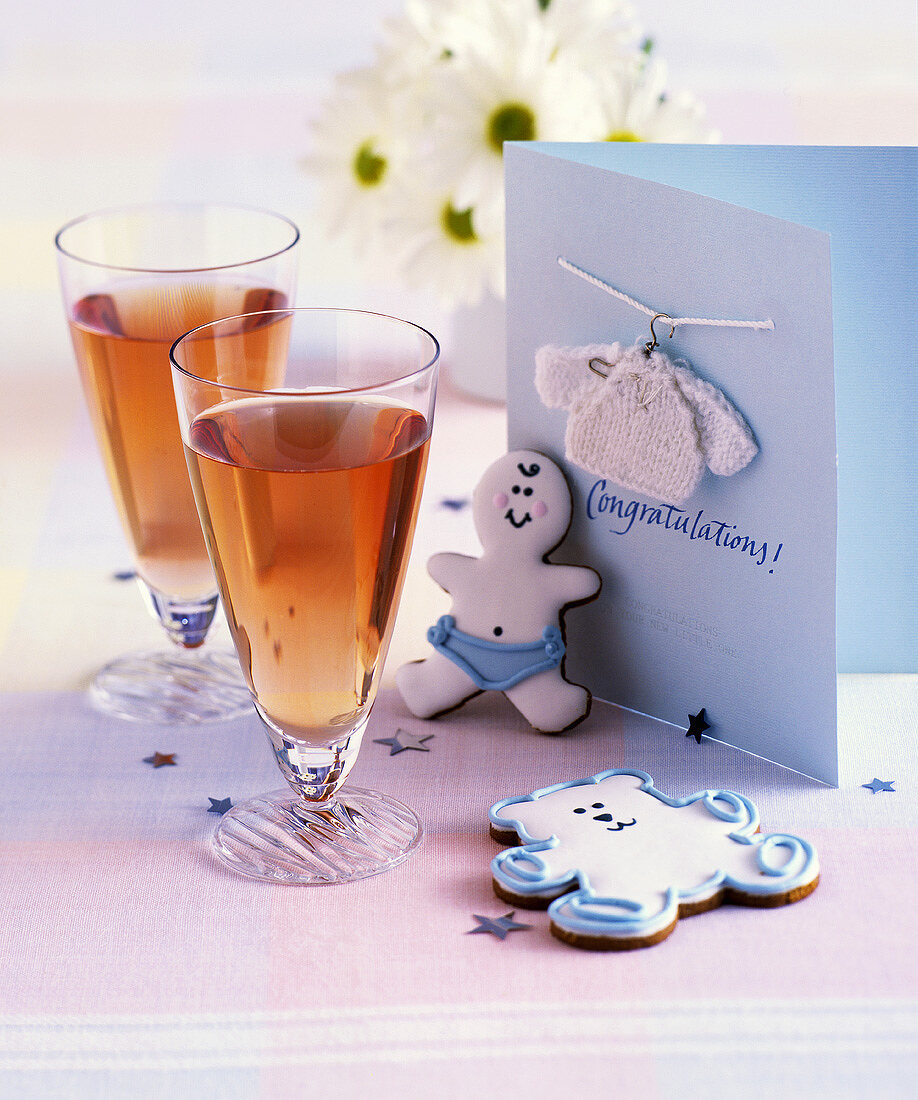 Birth congratulations card, decorated biscuit and drinks