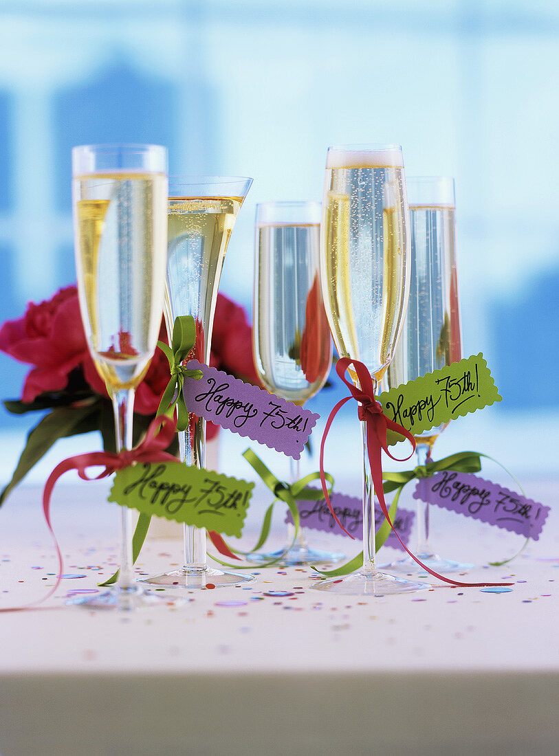 Glasses of sparkling wine with 75th birthday labels