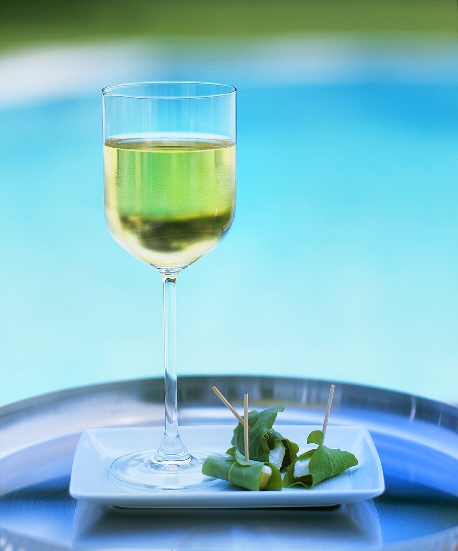 A glass of white wine with appetisers