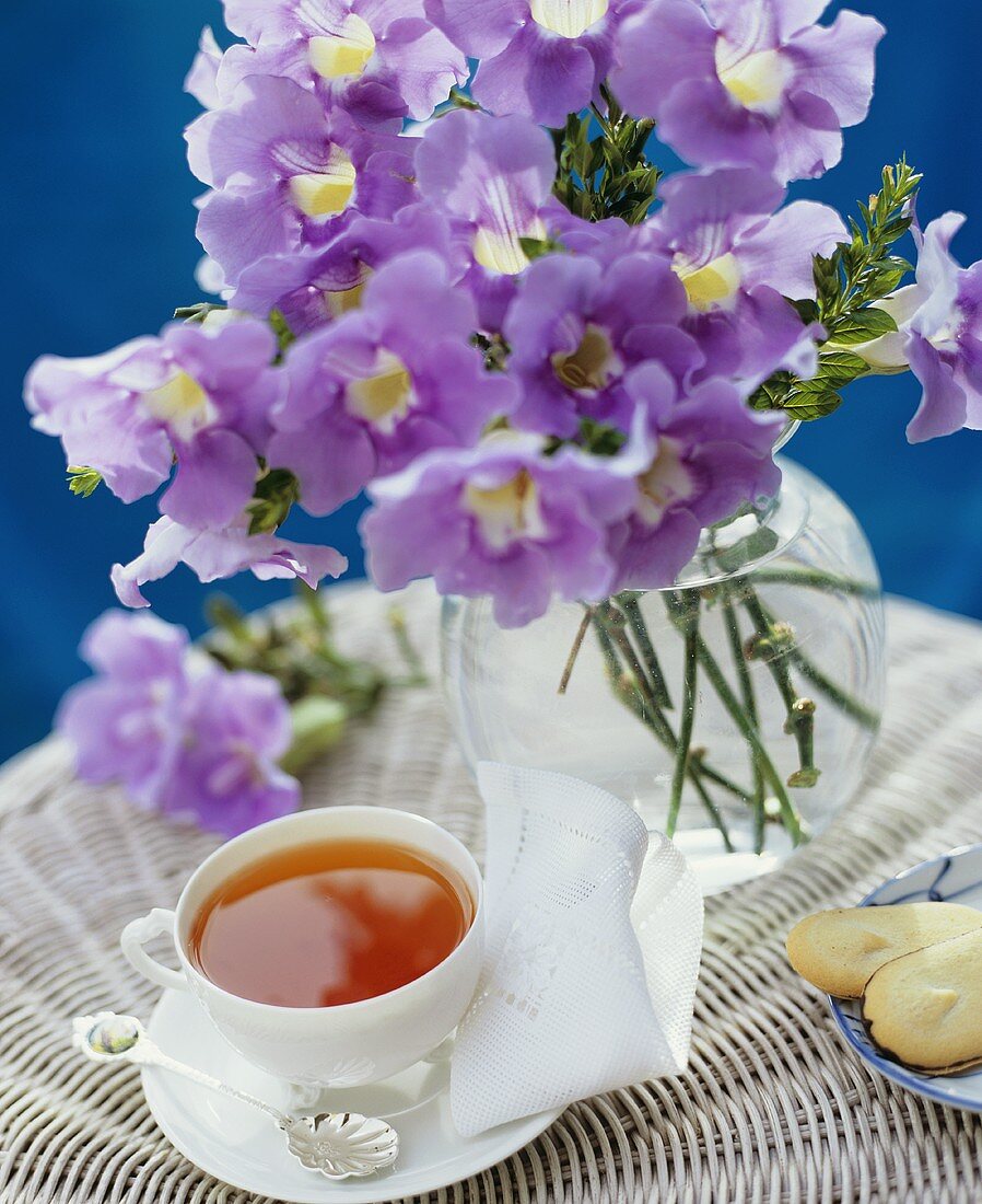 A cup of tea, biscuits and flowers