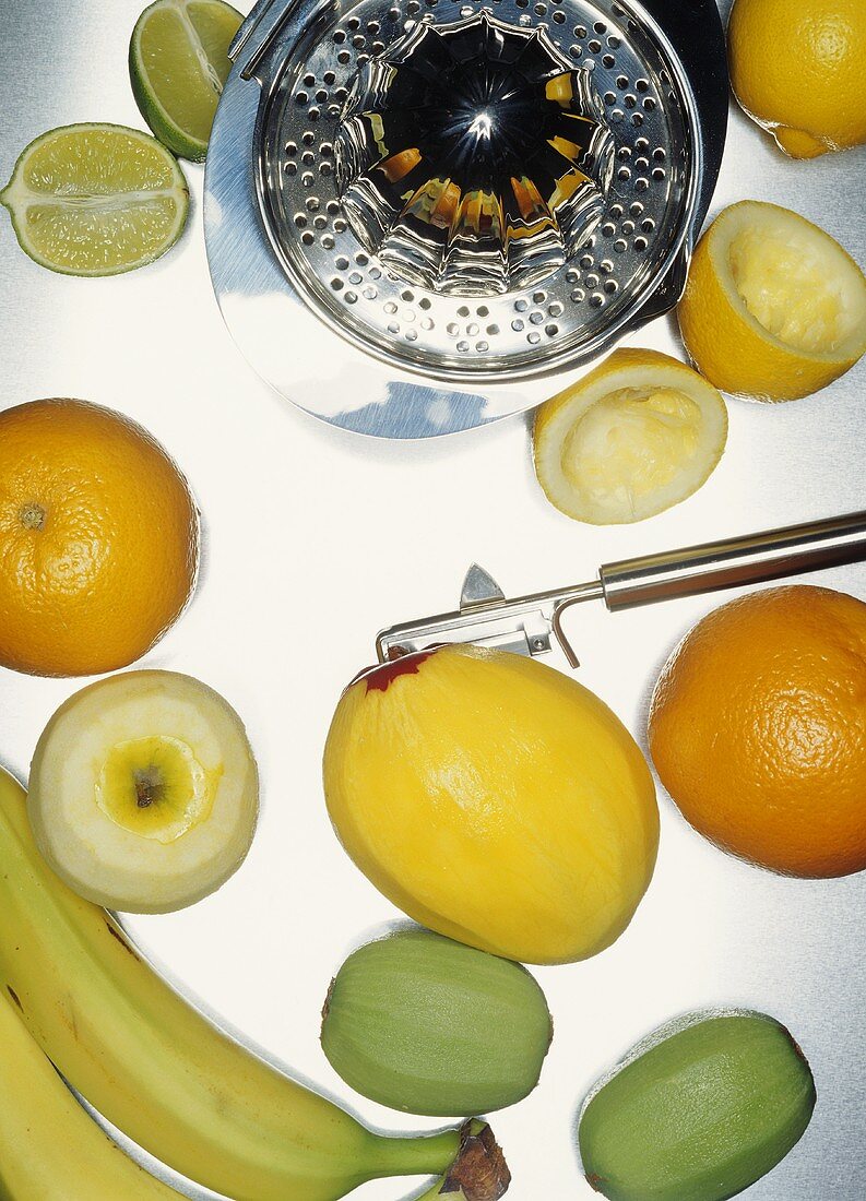 Fruit (some peeled), vegetable peeler, lemon squeezer