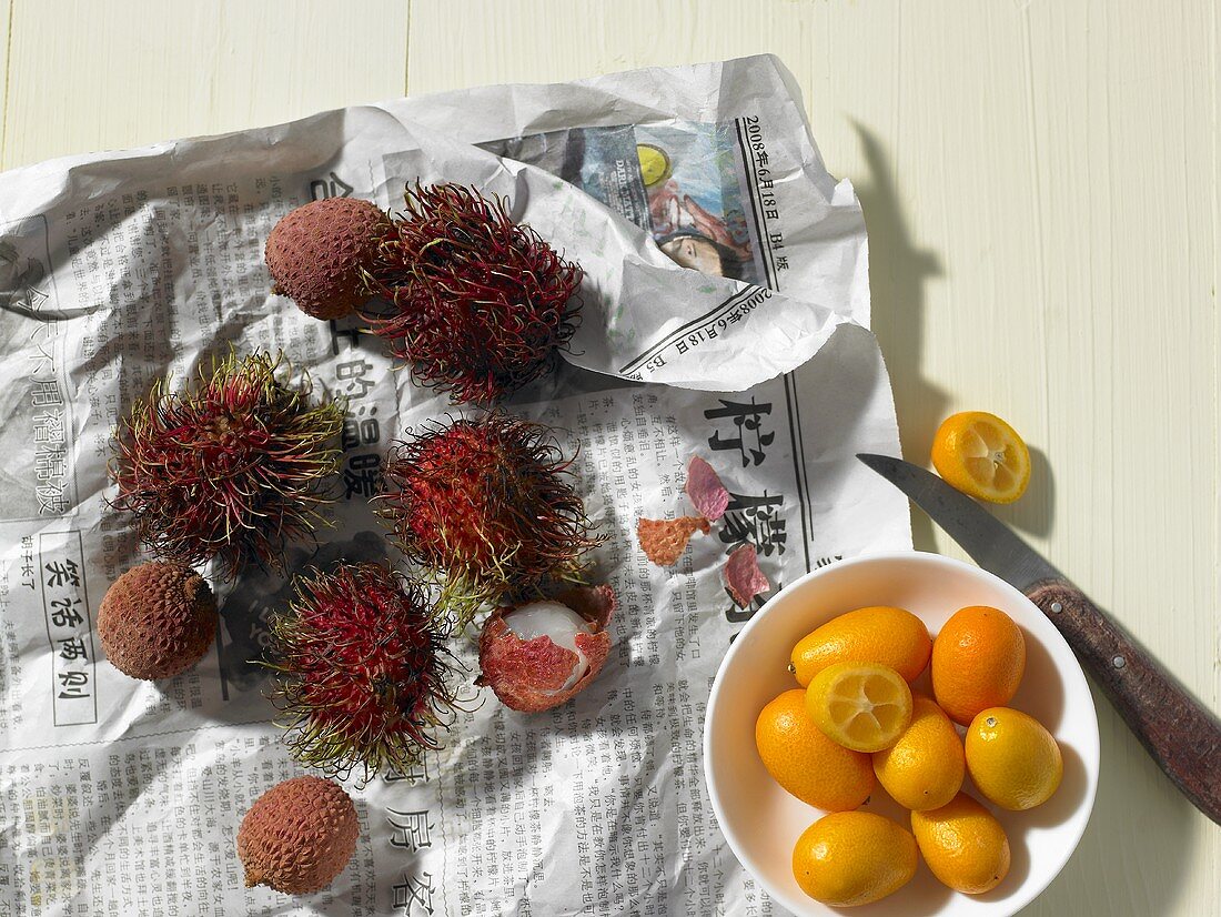 Lychees, Rambutan und Kumquats auf Thailändischer Zeitung