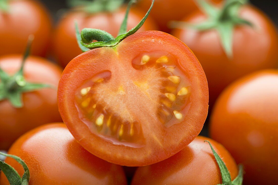 Eine halbe auf mehreren ganzen Tomaten