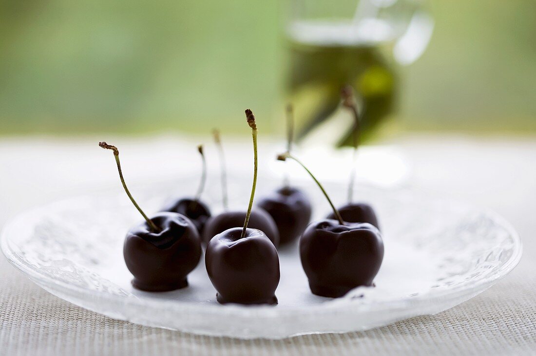 Chocolate-dipped cherries on a glass platter