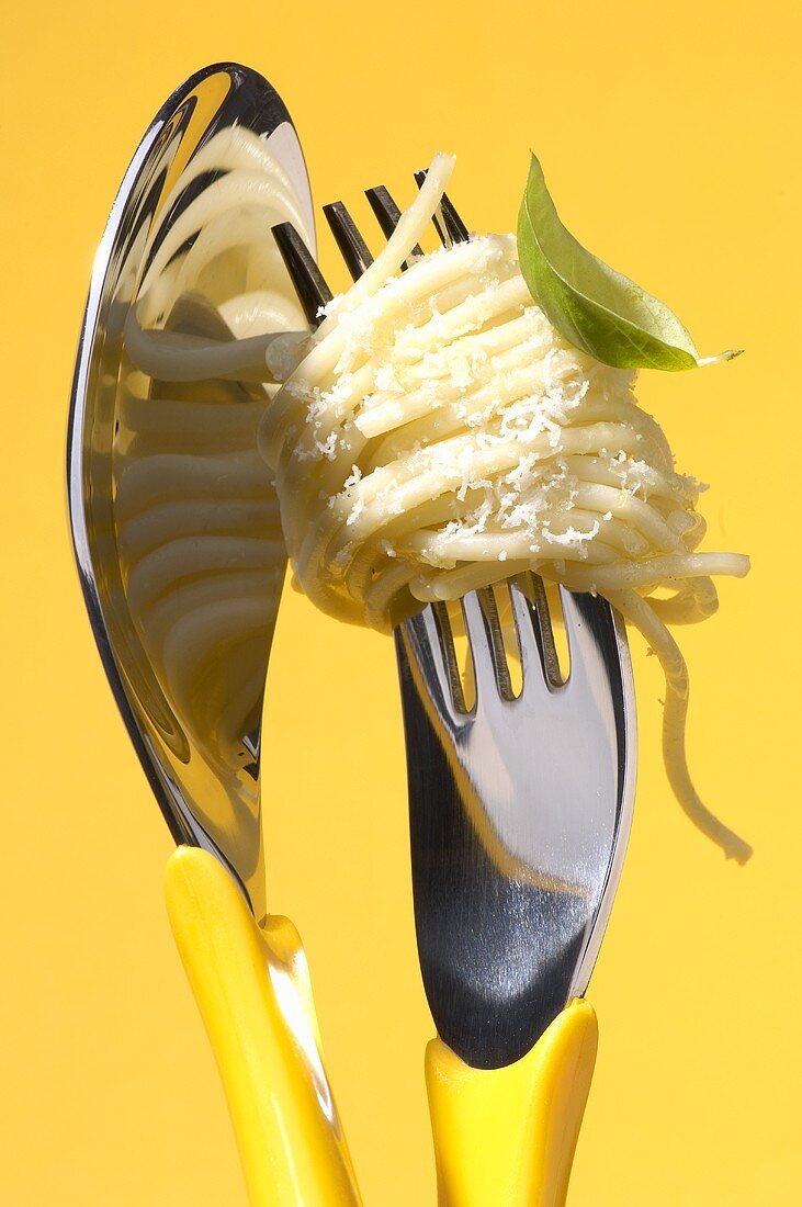 Spaghetti mit geriebenem Parmesan auf Gabel und Löffel