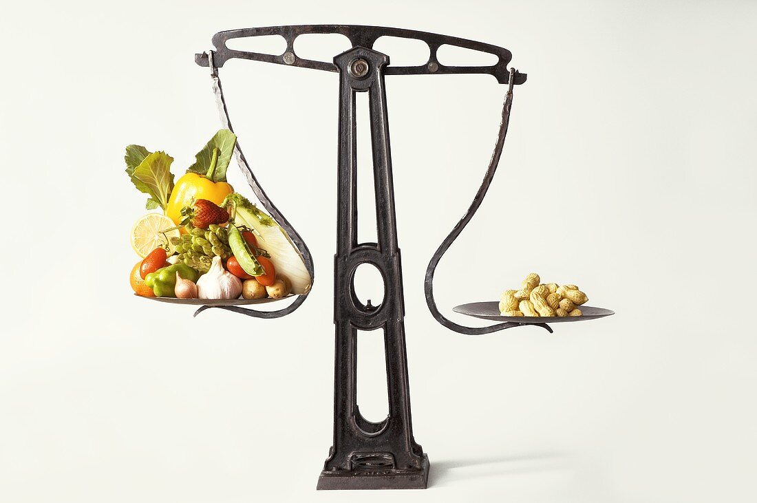 Symbolbild Diät: Waage mit Gemüse und Erdnüssen