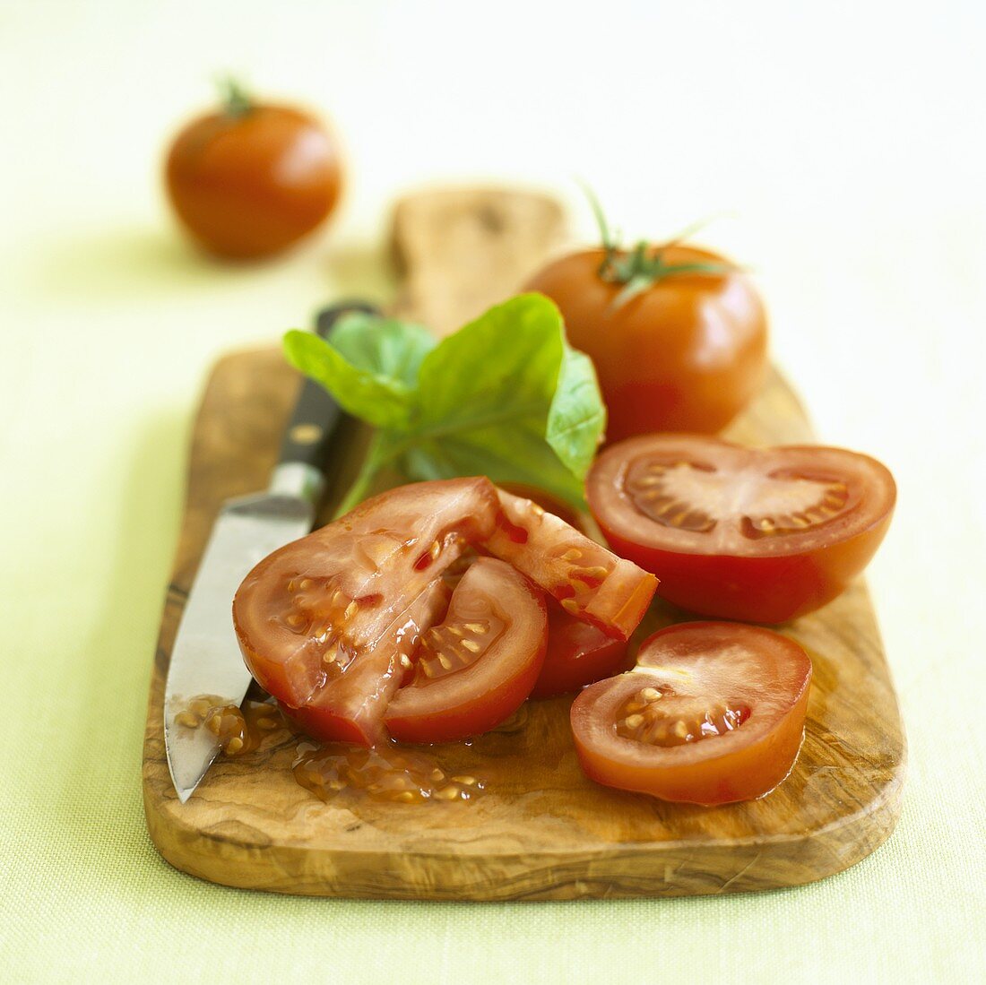 Aufgeschnittene Tomaten mit Basilikum und Messer