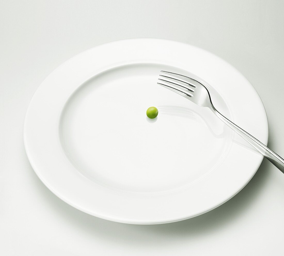 A pea on a plate with a fork