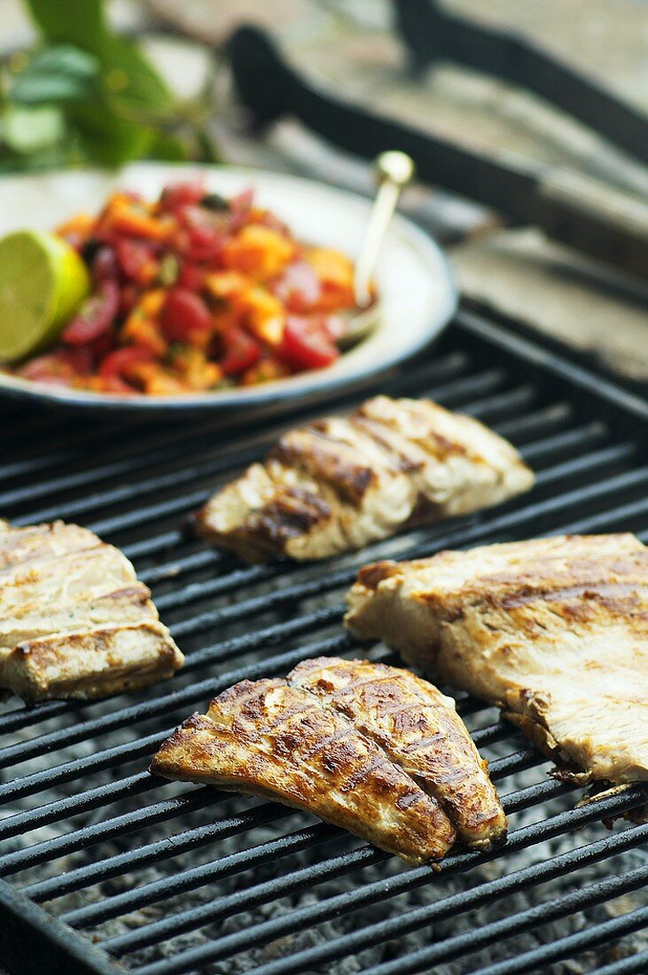 Fish fillets on barbecue with tomato and papaya salsa