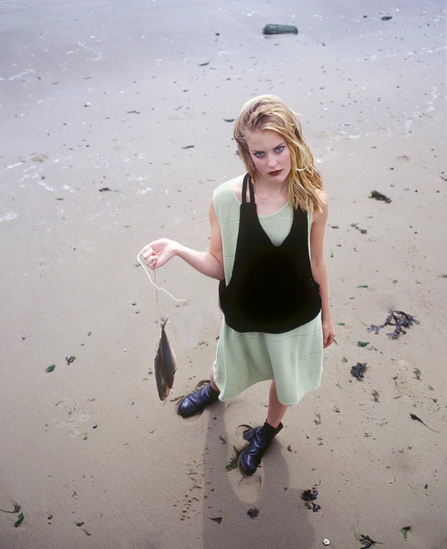 Young woman with two herrings on a string