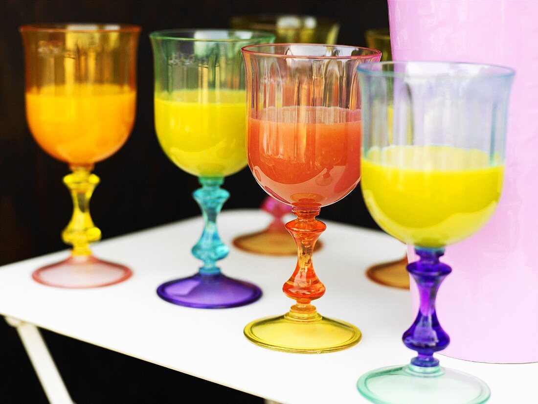 Orange juice in coloured glasses