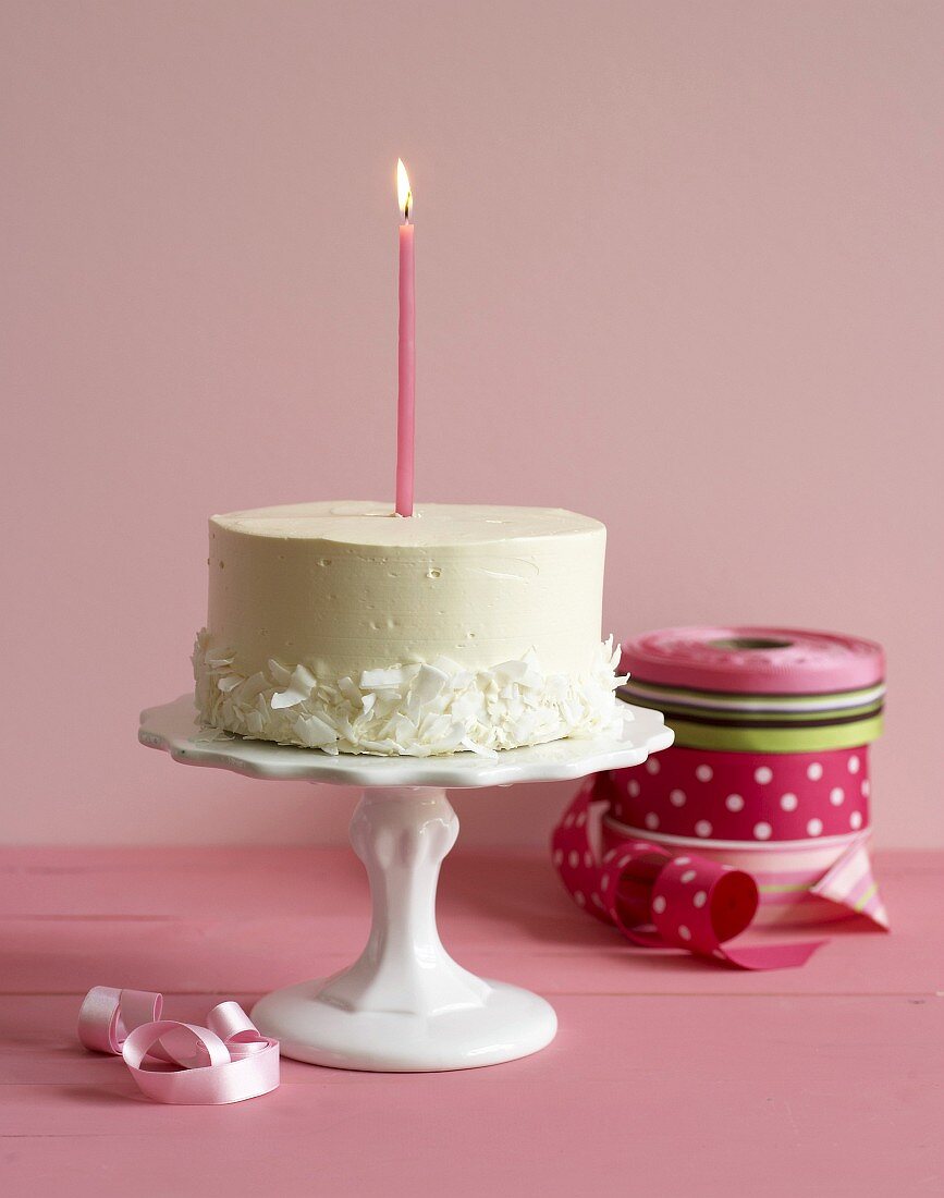 A cake with candle on a cake stand