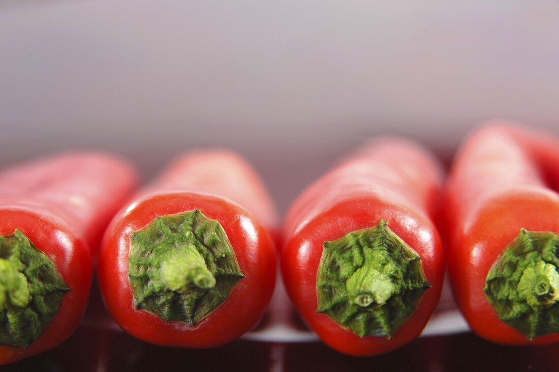 Several red pointed peppers in a row