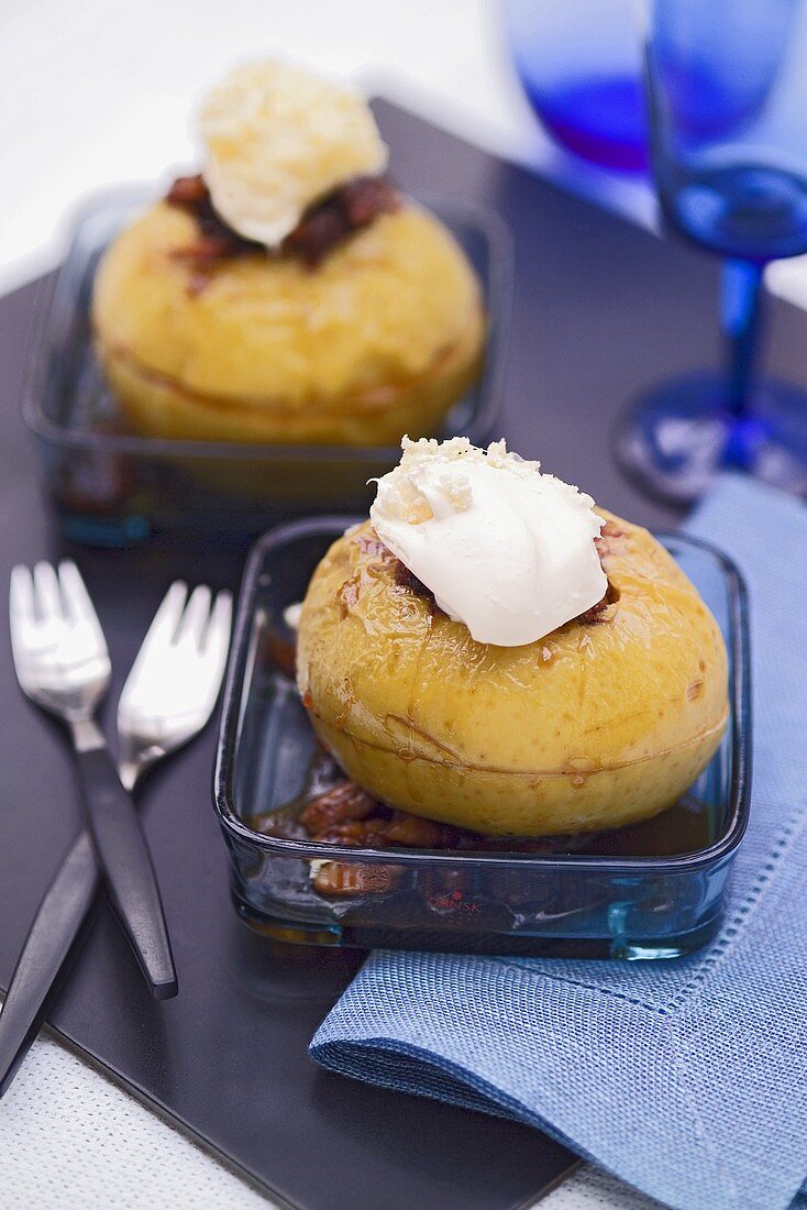 Two baked apples with raisins, nuts and cream