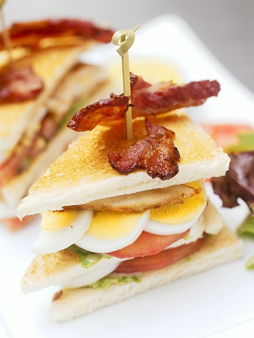 Two club sandwiches with bacon