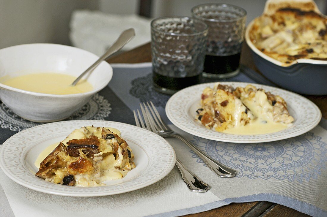 Two plates of bread and butter pudding with custard