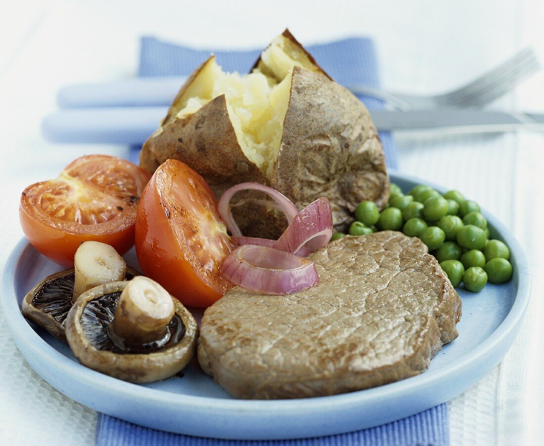 Beef steak with mushrooms, tomatoes, peas, baked potato