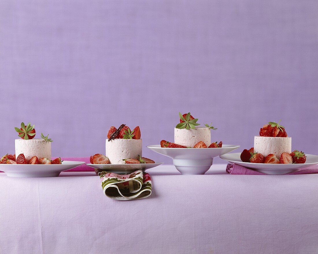 Mascarpone cream moulds with strawberries on different plates