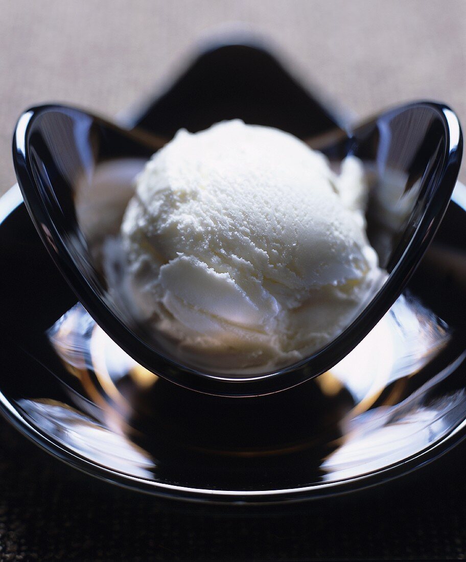 A scoop of yoghurt ice cream in a glass dish