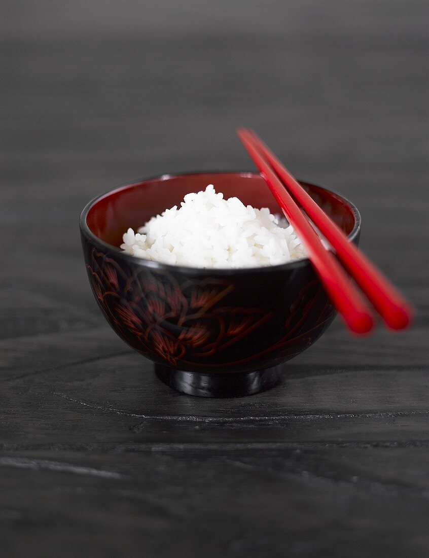 Eine Schale mit Reis und Essstäbchen