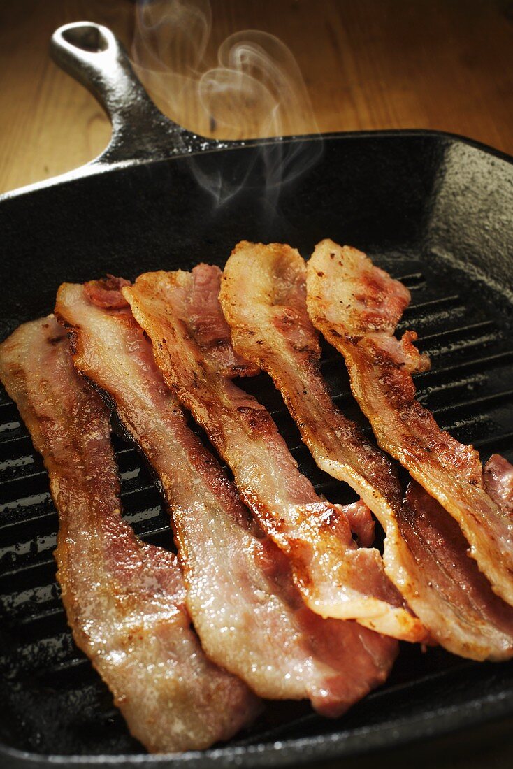 Frying bacon in a grill frying pan