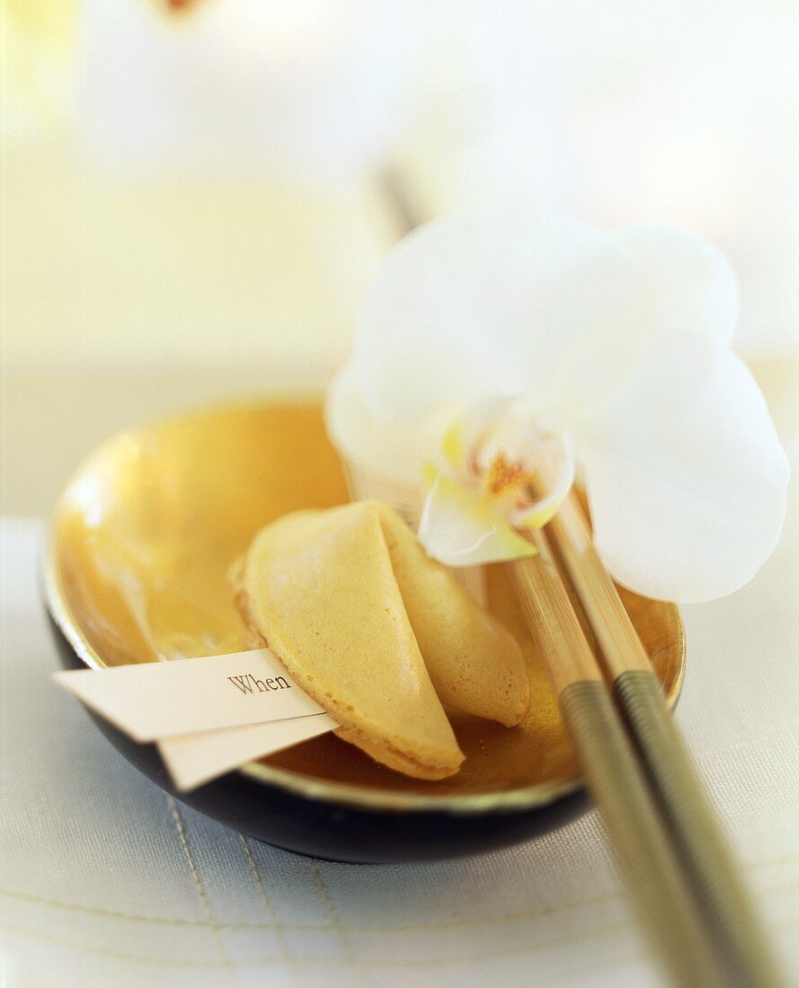 Asian table setting with fortune cookie and orchid 
