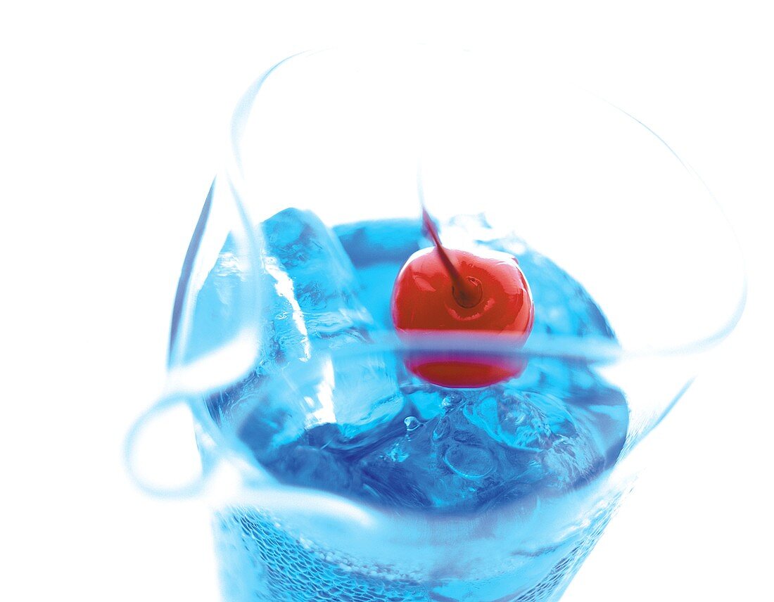 Ein Krug Curacao-Drink mit Cocktailkirsche