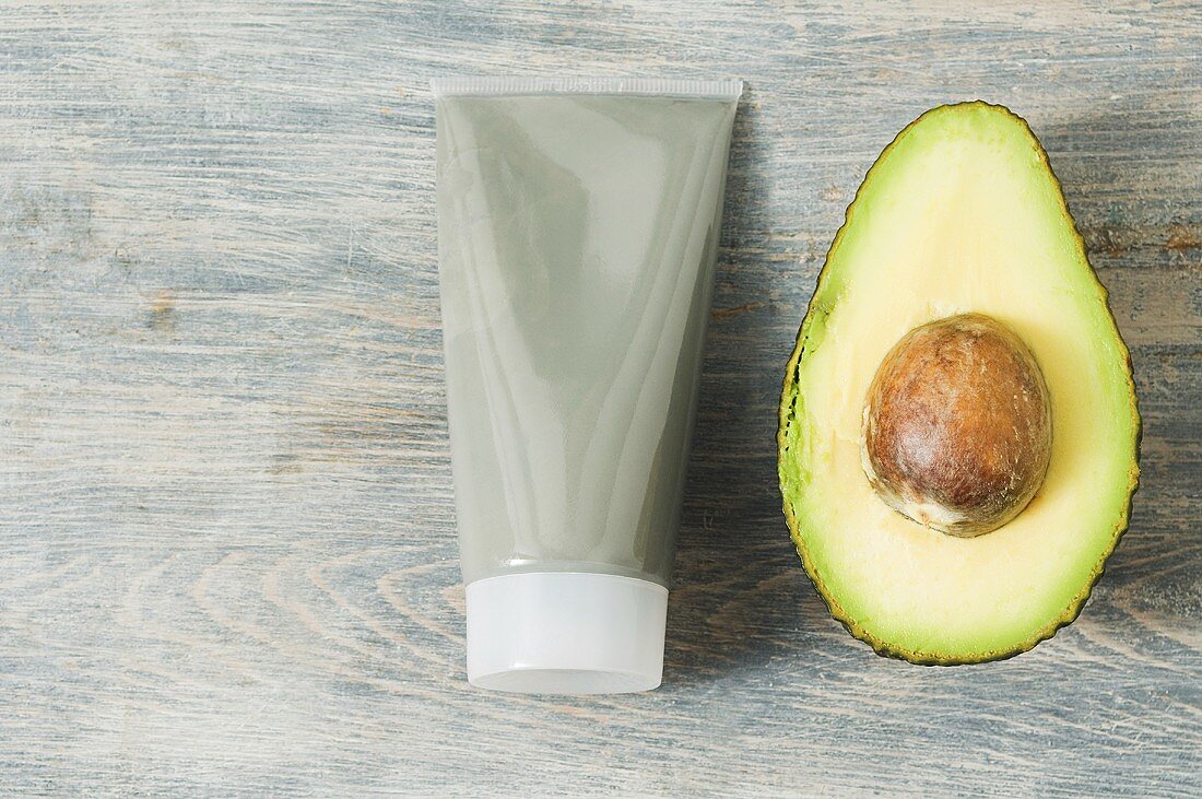 Tube of face mask and avocado
