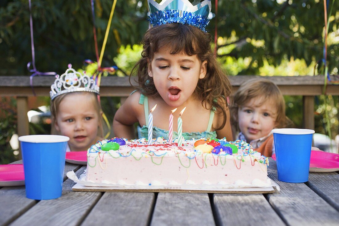 Girl blowing out candles on cake