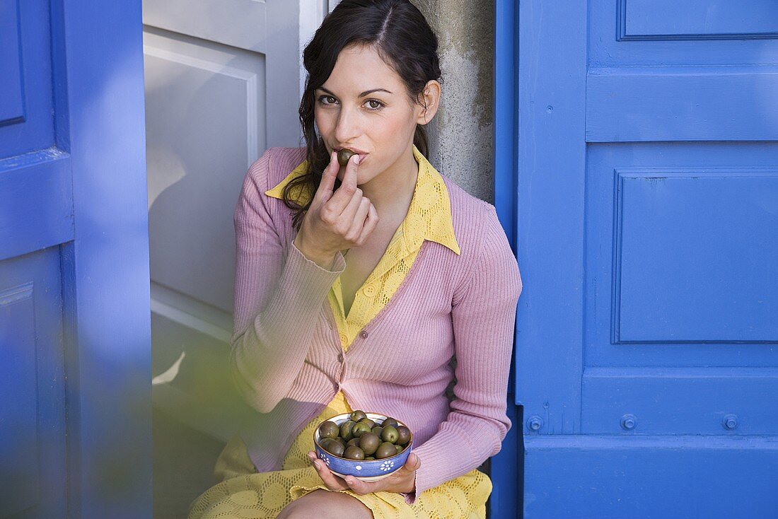 Italienische Frau isst Oliven aus einer Schale
